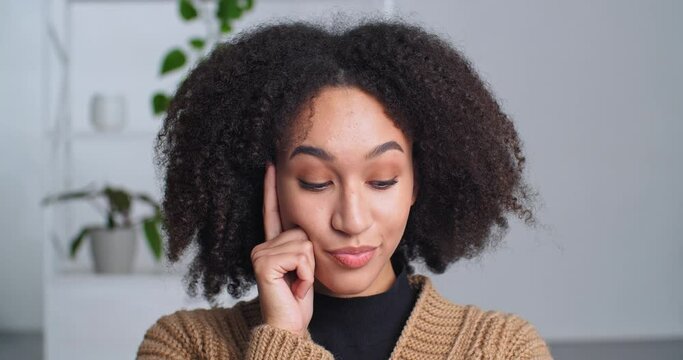Portrait pensive flirtatious afro american girl ethnic woman sitting touching her chin with finger thinking about ideas making choice emotional female face closeup planning future recalls past dreams