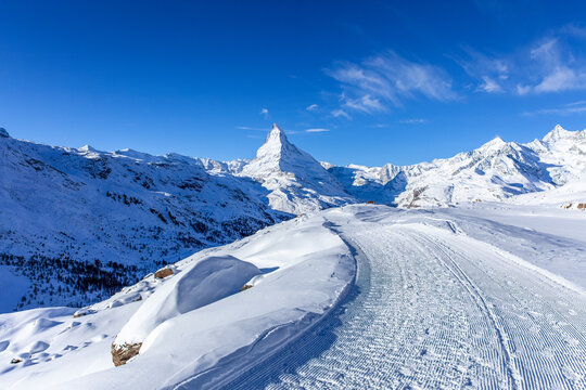 Hiking path in front of the Matterhorn  in the morning light in winter. Photo taken from the hiking trail from Blauherd to Fluhalp, above Zermatt in Valais, Switzerland.