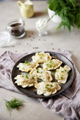 Christmas dumplings stuffed with mushrooms and cabbage on a white plate on a rustic wooden table. A traditional dish on Christmas Eve in Poland. Dumplings, dumplings, pies, pies - stuffed dumplings.