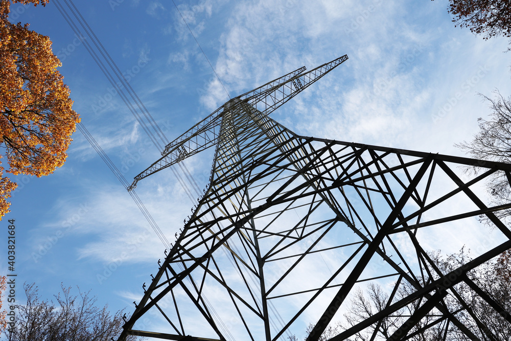 Wall mural Low angle shot of a transmission line under the blue daylight sky