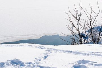 Spacious snow landscape. River and hills in Russia, white winter on the terrain, a lot of fluffy snow and ice