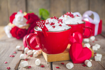 Valentine hot chocolate or coffee, Two red cups with hot chocolate or latte drink, with whipped cream ans sugar heart sprinkles, with roses bouquet ad gift box