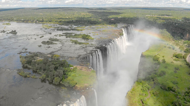 Die Viktoriafälle in Sambia und Simbabwe mit dem Sambesi Fluss und einem Regenbogen aus der Vogelperspektive