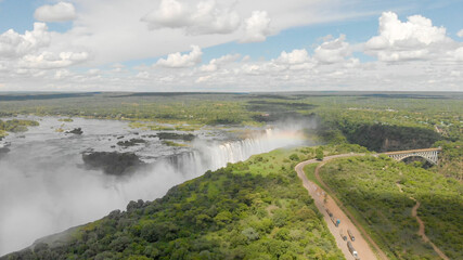 Die Viktoriafälle in Sambia und Simbabwe mit dem Sambesi Fluss und einem Regenbogen, aufgenommen aus einem Helikopter