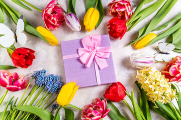 Festive flower composition and gift box on light background. Holiday concept with bouquet of spring flowers. Valentine, Mothers day, wedding, 8 march concept. Top view