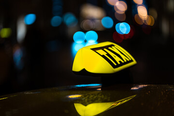 Closeup of a yellow TAXI sign on the taxi captured at night