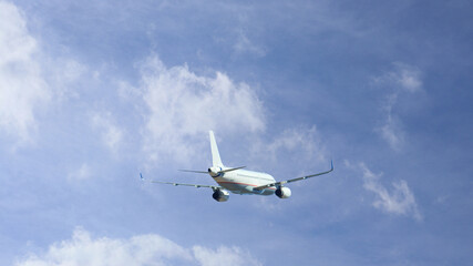 Fototapeta na wymiar Zoom photo of passenger airplane taking off in cloudy deep blue sky