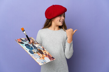 Artist girl over isolated background pointing to the side to present a product