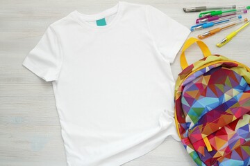 White cotton boy  t-shirt mockup for design, template, colorful backpack and school supplies, flat...