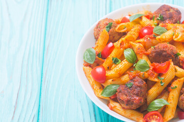 Italian penne pasta with meatballs and tomatoes