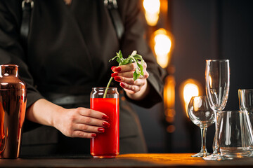 Closeup on woman making bloody mary cocktail with celery stalk