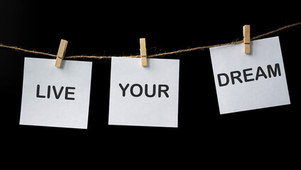 Live your Dreams on white stickers on black background. Motivational phrase. Minimalism and...