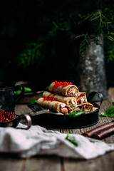 pancakes with red caviar fish and cream cheese on a wooden background