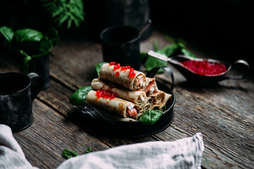 pancakes with red caviar fish and cream cheese on a wooden background
