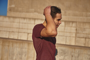 Handsome young man brushes his hair back