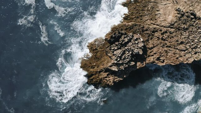 ocean waves hit the rock, rotating topshot aerial view in Portugal. High quality 4k footage