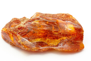 A piece of unique transparent yellow amber on a white background. A semi-precious stone made from petrified resin. Material for jewelry and ornaments. Copal. Sun stone. Fossil resin. Baltic gem.