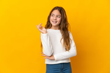 Child over isolated yellow background pointing up a great idea