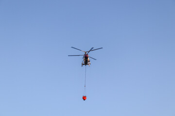 helicopter flying over the sky and extinguishes a fire