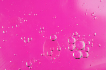 oil drops on water on a pink background