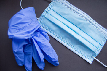 Protection rubber gloves and mask on black background