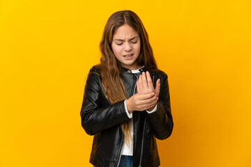 Child over isolated yellow background suffering from pain in hands