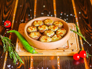Mushrooms on ketsi. Champignons baked with cheese. Georgian food. Side view.