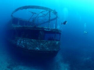 scuba divers exploring shipwreck scenery underwater ship wreck deep blue water ocean scenery of...