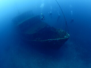 scuba divers exploring shipwreck scenery underwater ship wreck deep blue water ocean scenery of...