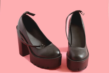 Women`s platform shoes on a pink background. Punk, grunge, goth women shoes.