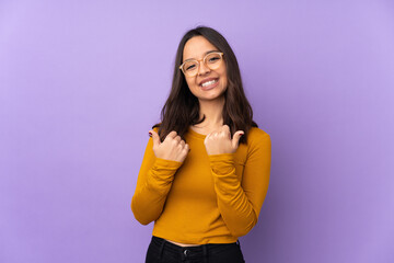 Young mixed race woman isolated on purple background with thumbs up gesture and smiling