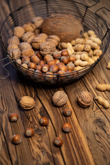 still life with hazelnut peanuts walnut and coconut on wooden board