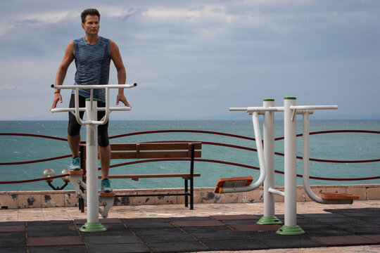 Man Trains Outdoor In The Park On Sports Equipment