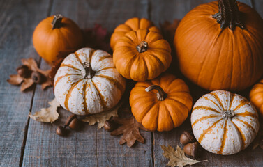 High angle view of orange and white pumpkins on rustic wooden table.
