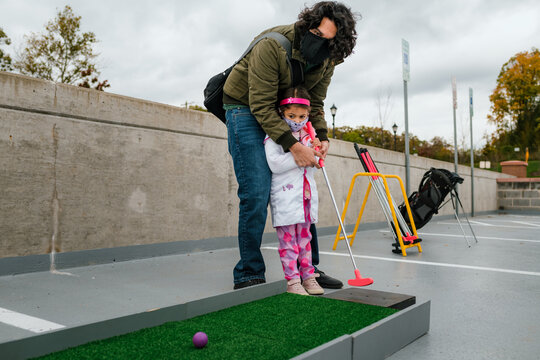 father and daughter playing mini golf in halloween costume