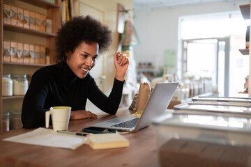 Happy black businesswoman teleworking in store