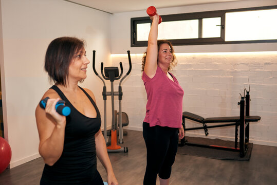 Two Women Are Doing Weight Training At Home