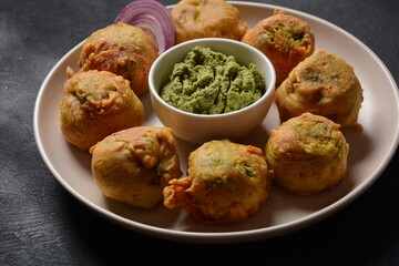 Batata vada  popular street food of India, Served with  green chutney.