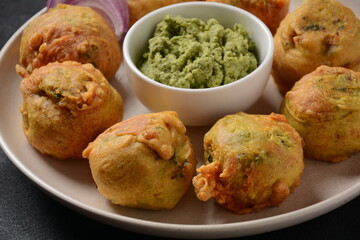 Batata vada  popular street food of India, Served with  green chutney.