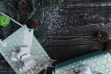 gift boxes in green packaging, decorations and fir branches on a dark background. Christmas and new year themes. Copy space	
