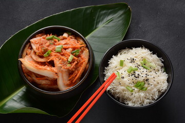 Kimchi and rice in black bowl with chopstick. Korean food
