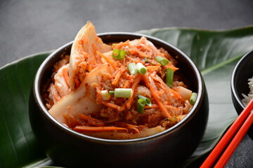 Kimchi and rice in black bowl with chopstick. Korean food