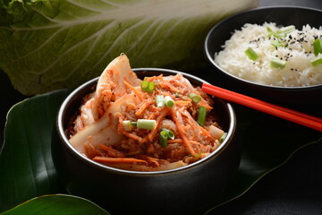 Kimchi and rice in black bowl with chopstick. Korean food