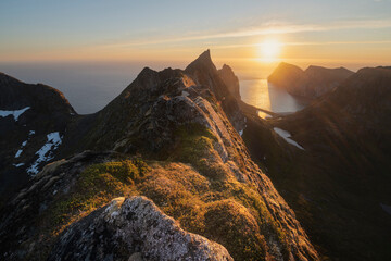 June midnight sun hangs low over sea above Kvalvika beach, Lofotodden national park, Moskenes√∏y, Lofoten Islands, Norway