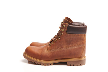Pair of Mens leather brown waterproof boots for winter or autumn hiking isolated on white background. Mens fashion, trendy footwear. Close up view.