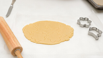 Cookie dough close up on white background. Flower shaped shortbread cookies close up baking process