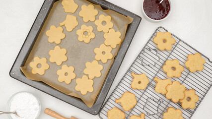 Shortbread cookies with raspberry jam recipe. Step by step baking process, flat lay. Cookies close up on baking pan and cooling rack