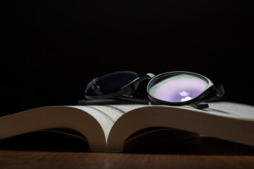 The eyeglasses on the book are placed on the table