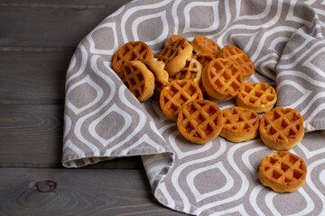 baked small soft waffles on a towel on a wooden table