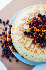 Breakfast Thin pancakes with frozen berries and honey